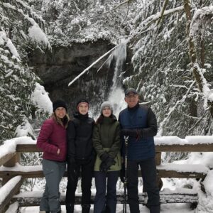 stephanie and her family in snow gear smiling in front of a wintry scene